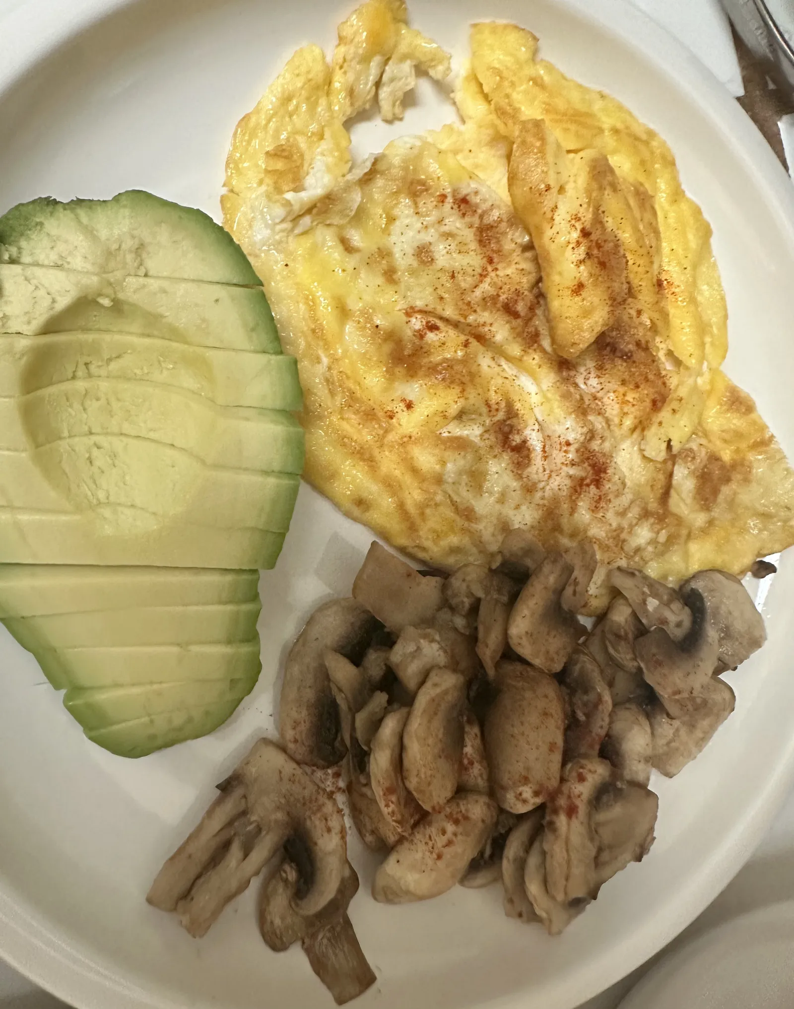 Scrambled eggs, sauteed mushrooms, and sliced avocados