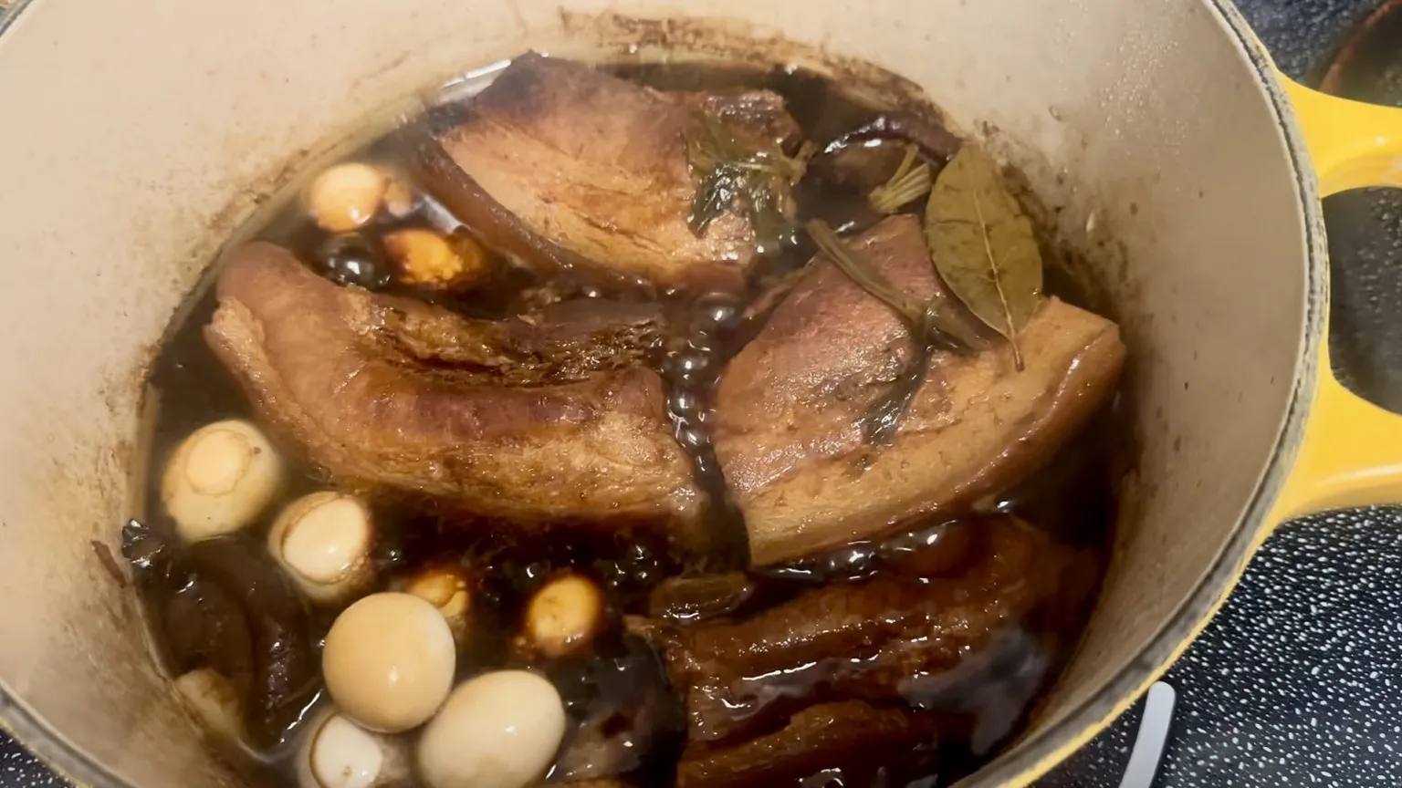 Glistening red-braised pork belly served in steamed buns with cucumber and cilantro