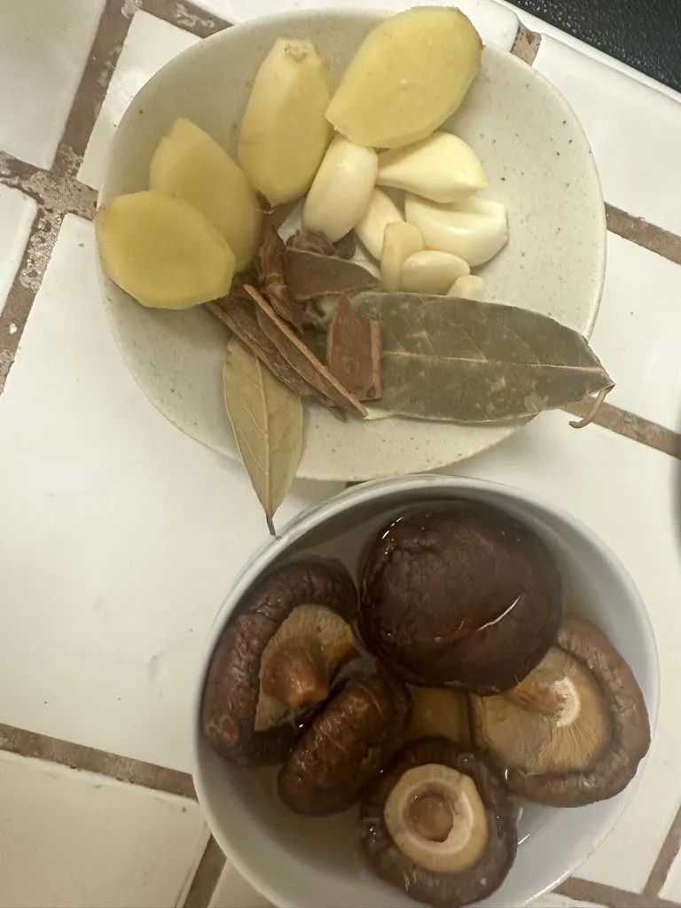 Aromatics laid out: star anise, cinnamon stick, bay leaves, ginger, and green onion