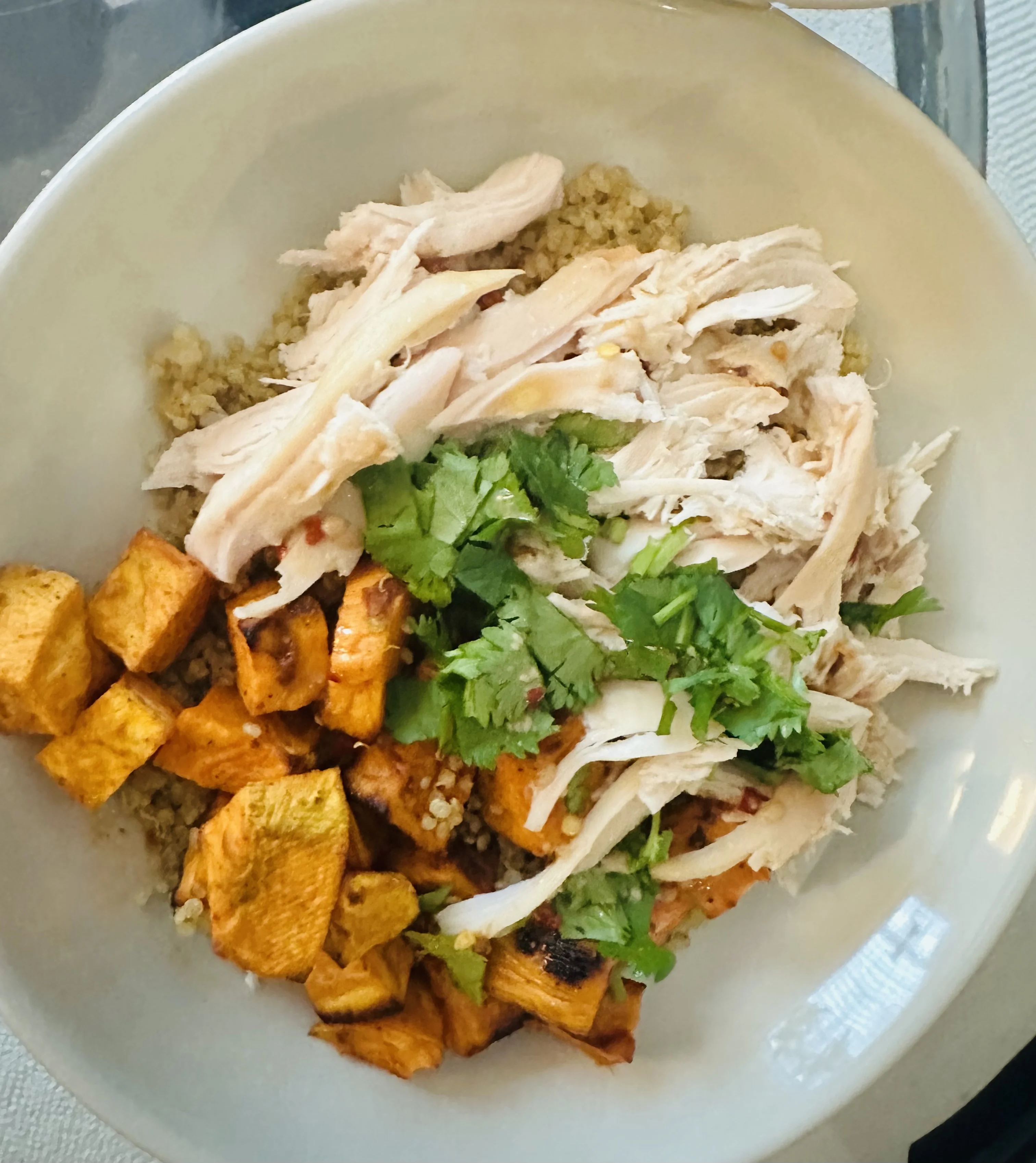 Hot honey chicken salad bowl with roasted sweet potato, quinoa, and fresh cilantro