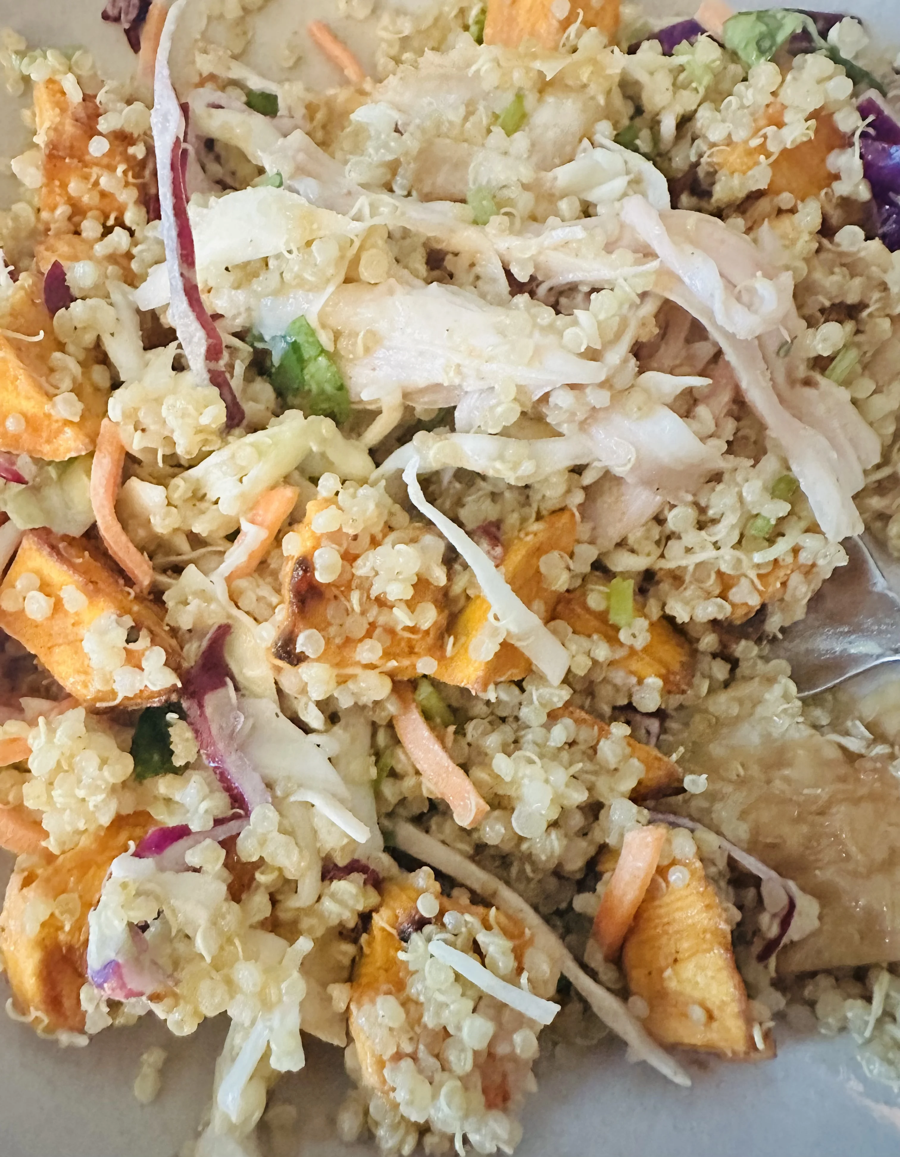 Hot honey chicken salad mixed together with quinoa, sweet potato, and cabbage